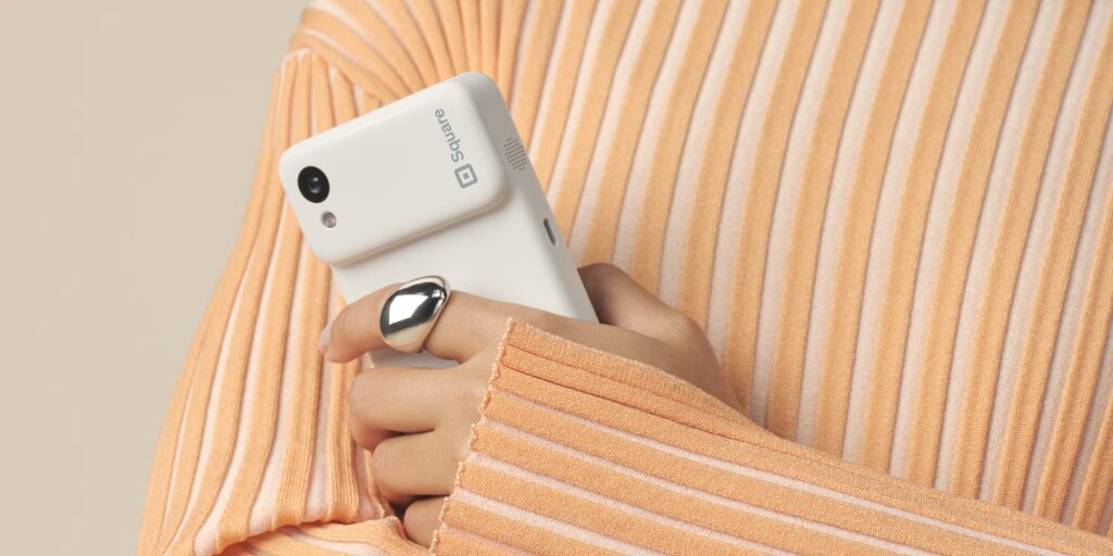 image of a person holding square credit card machine